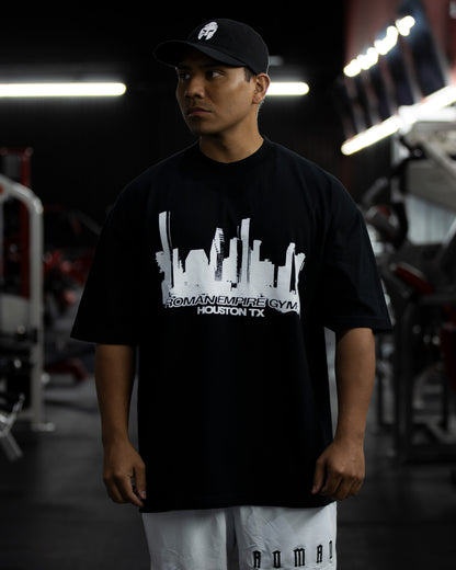 Person wearing a black t-shirt with a graphic design in a gym setting