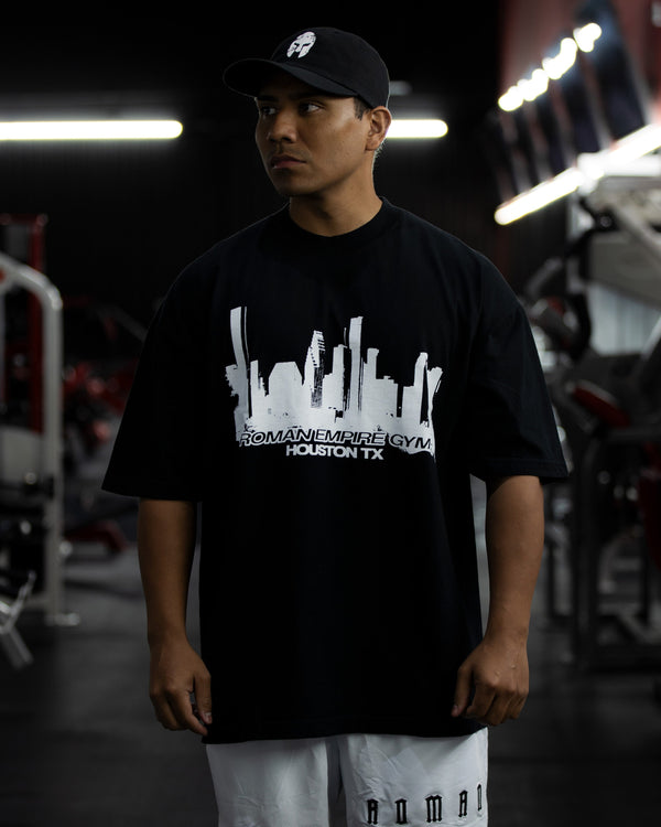 Person wearing a black t-shirt with a graphic design in a gym setting